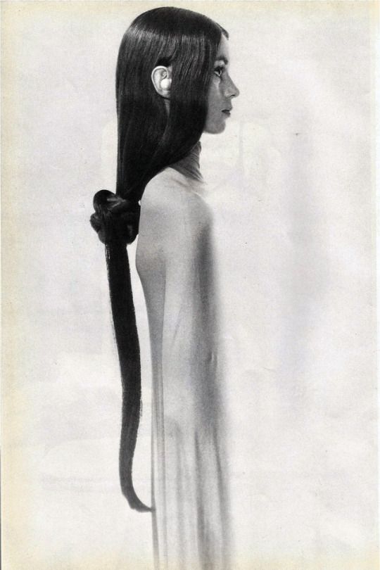 a black and white photo of a woman's head with long hair in a ponytail