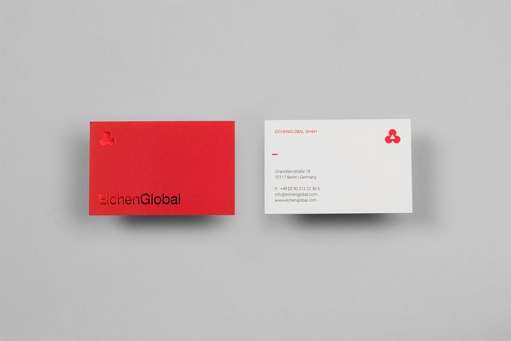 a red and white business card sitting on top of a gray surface