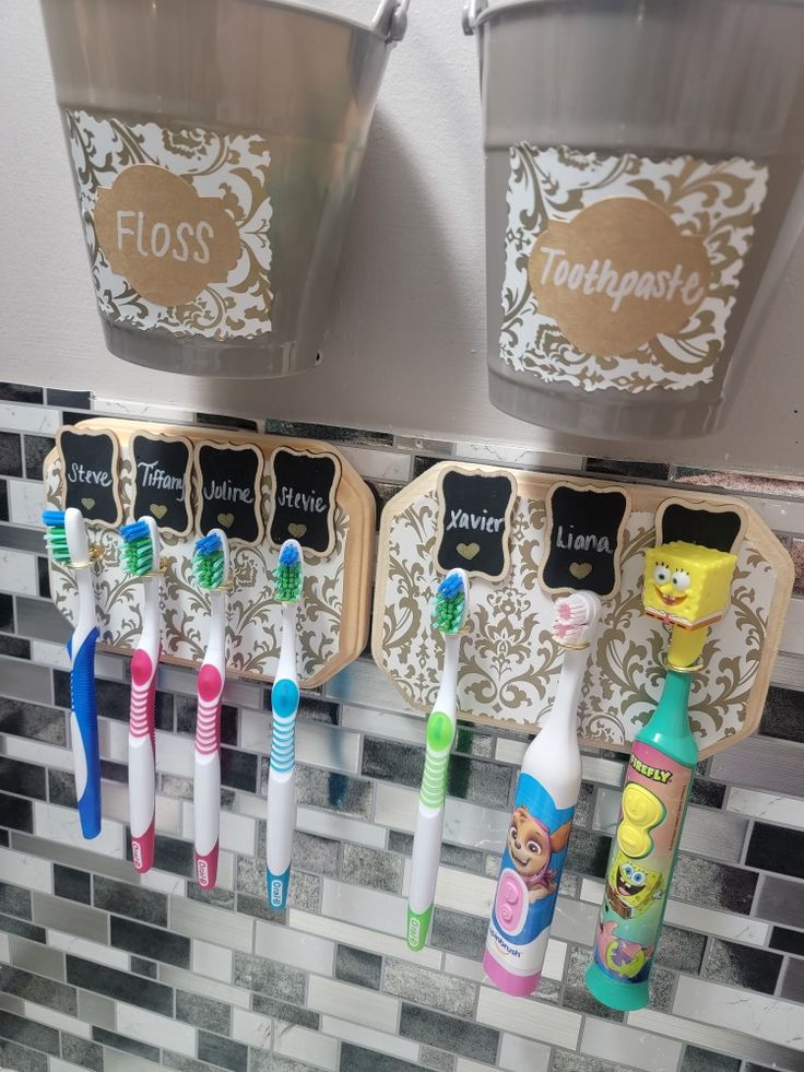 several toothbrushes and toothpaste are hanging on the wall next to each other