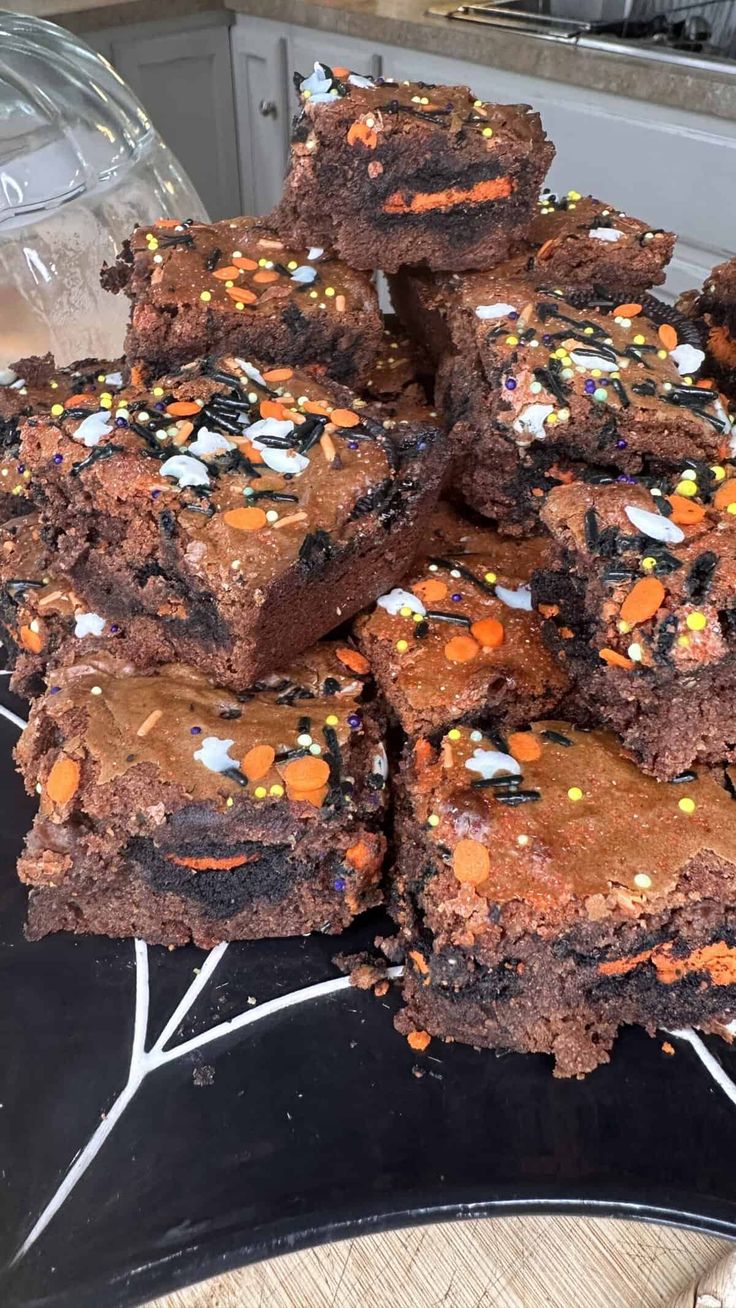 a pile of brownies sitting on top of a black plate