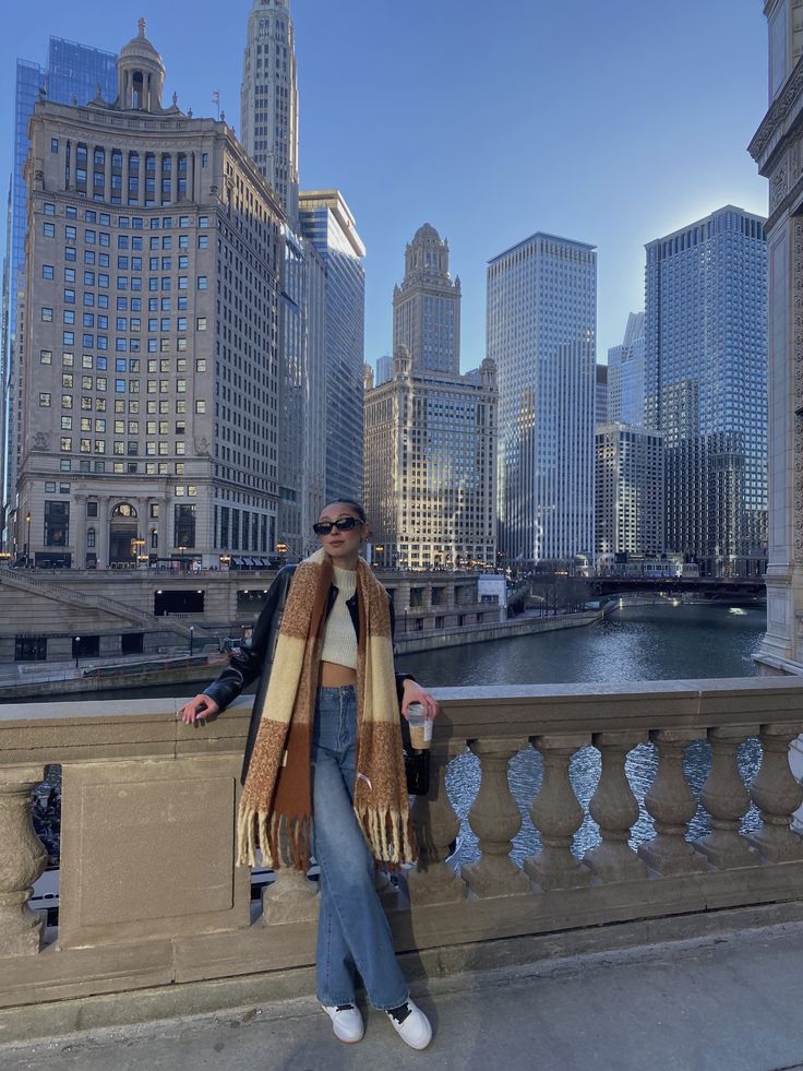 a woman is standing on a bridge in the city