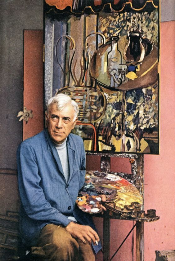 an older man sitting in front of a painting