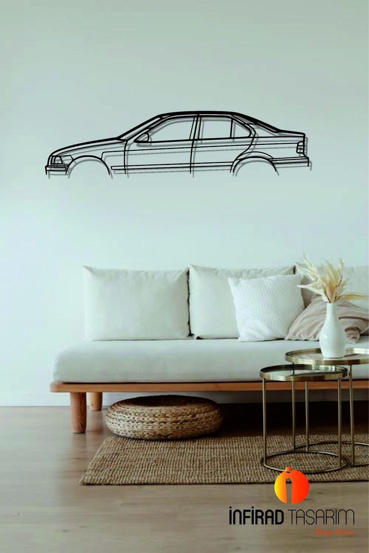 a living room with a white couch and black car wall decal on the wall