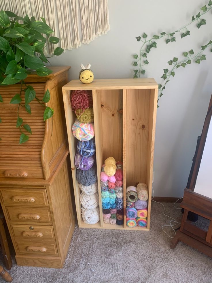 a wooden cabinet filled with lots of yarn