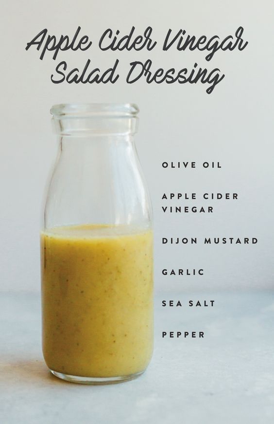 an apple cider vinegar salad dressing in a glass jar with the ingredients labeled below