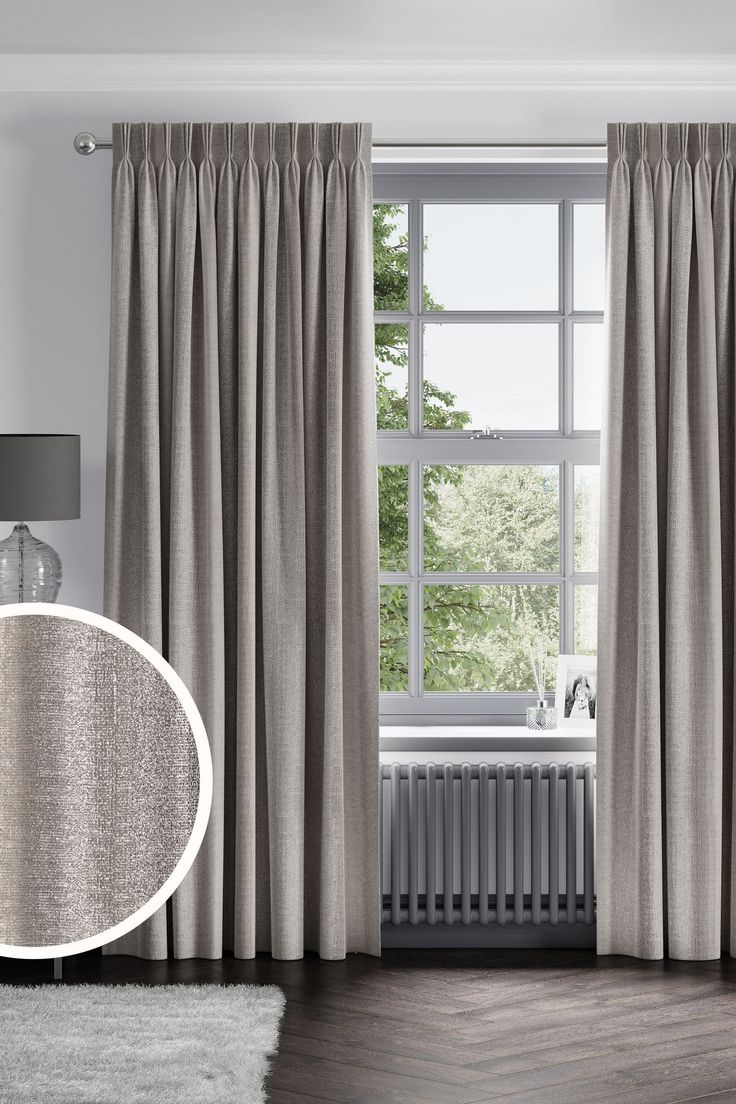 a living room with a large window covered in curtains and a radiator next to it