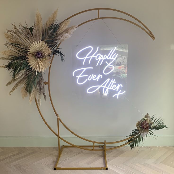 a neon sign that says happily ever after on the wall next to flowers and plants