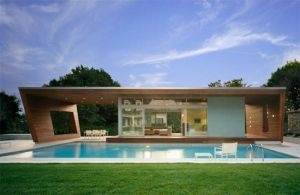 a house with a swimming pool in the middle of it's lawn and grass area