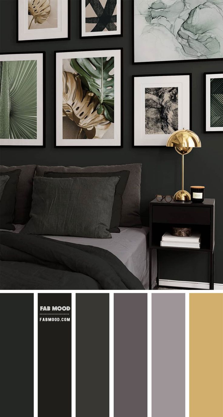 a bedroom with black walls and pictures on the wall, along with grey bedding