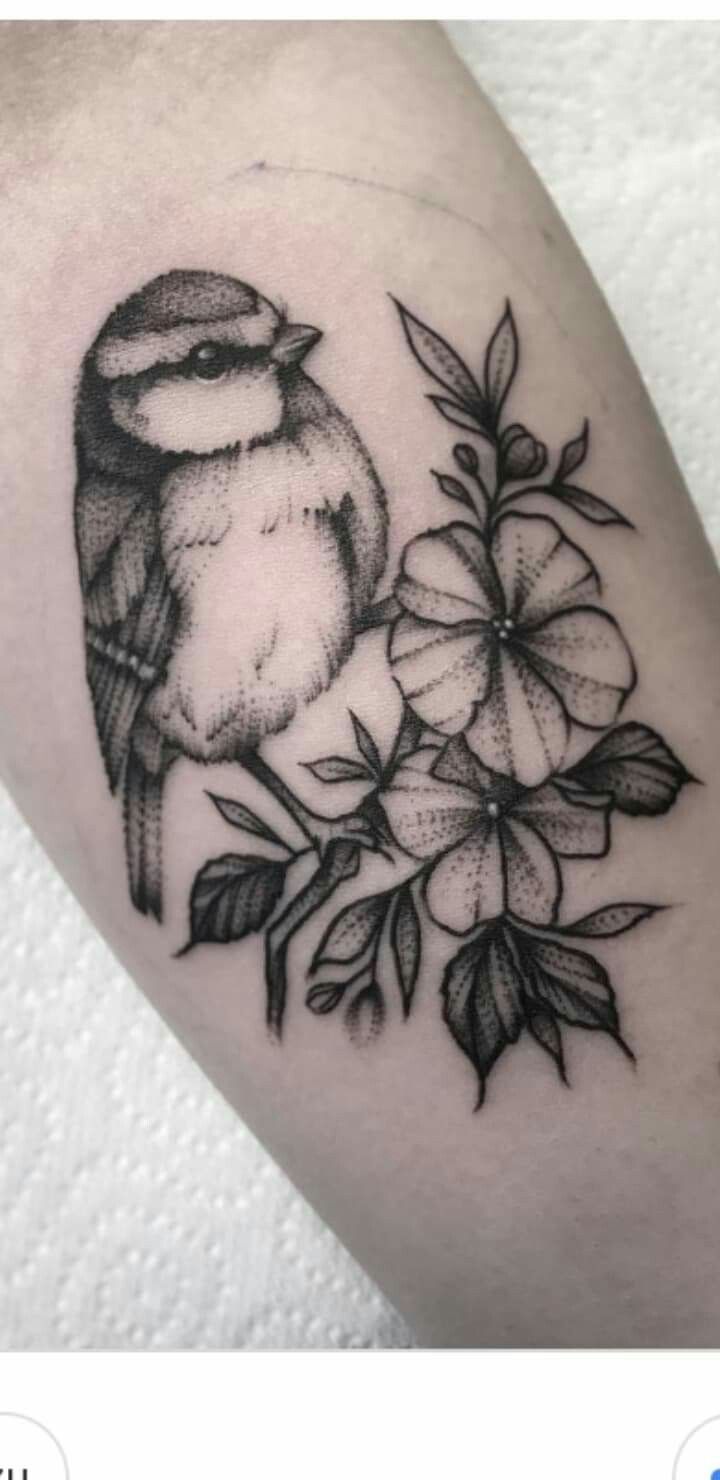 a bird sitting on top of a branch with flowers