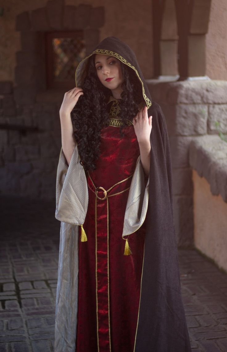 a woman in a red dress and black cape