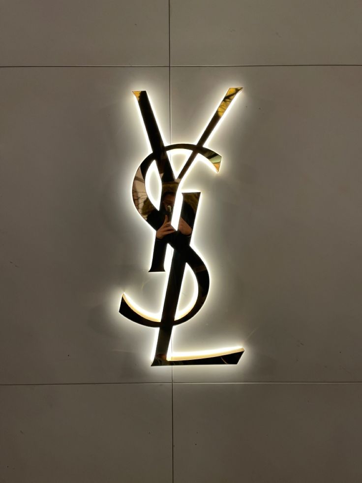 the ysl logo is lit up against a wall