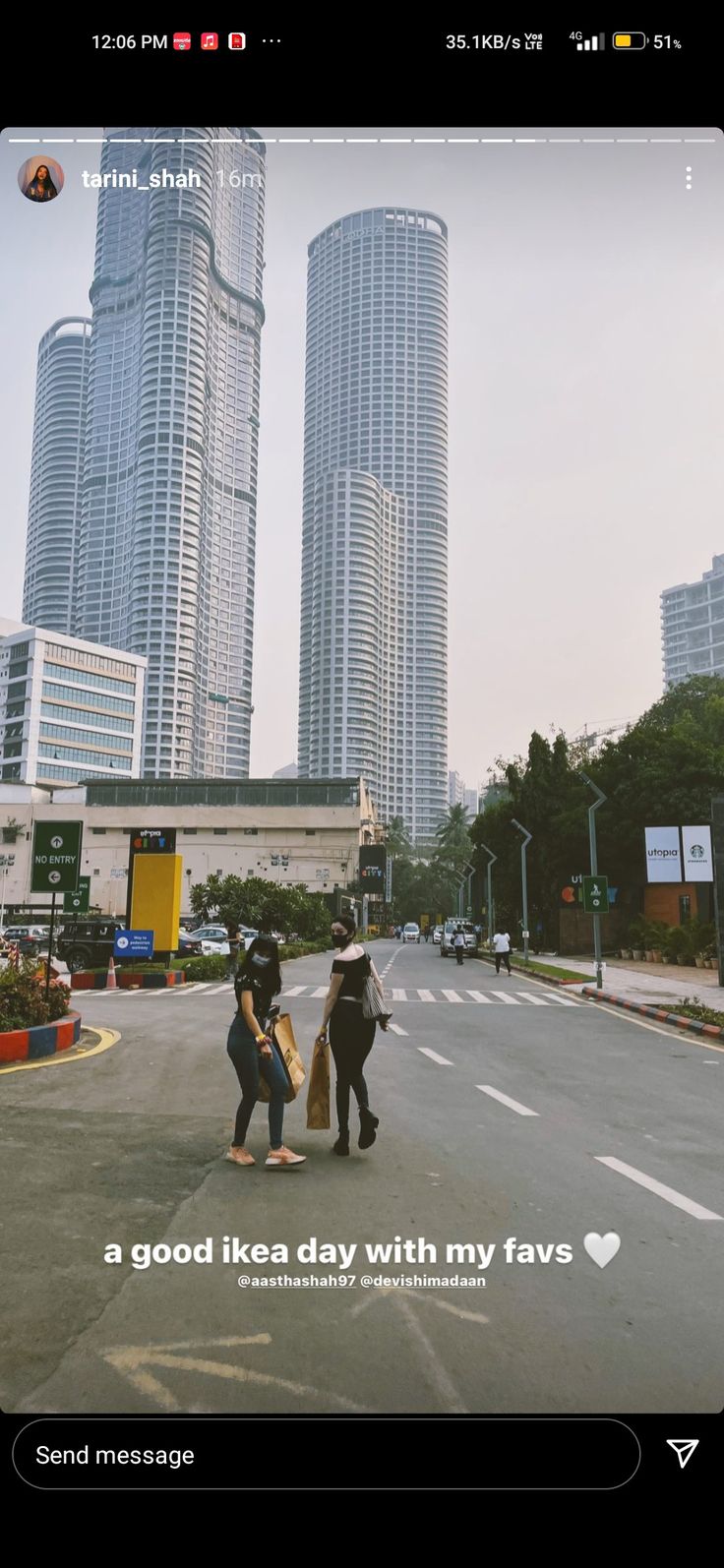 two people standing in the middle of an empty street with tall buildings on either side