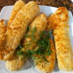 some fried food on a white plate sitting on a table