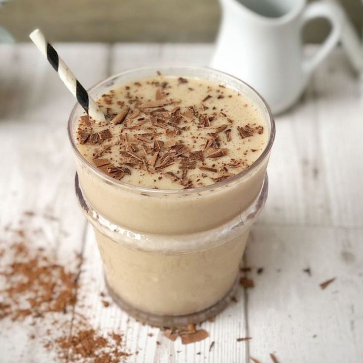 two glasses filled with chocolate milkshakes on top of a table