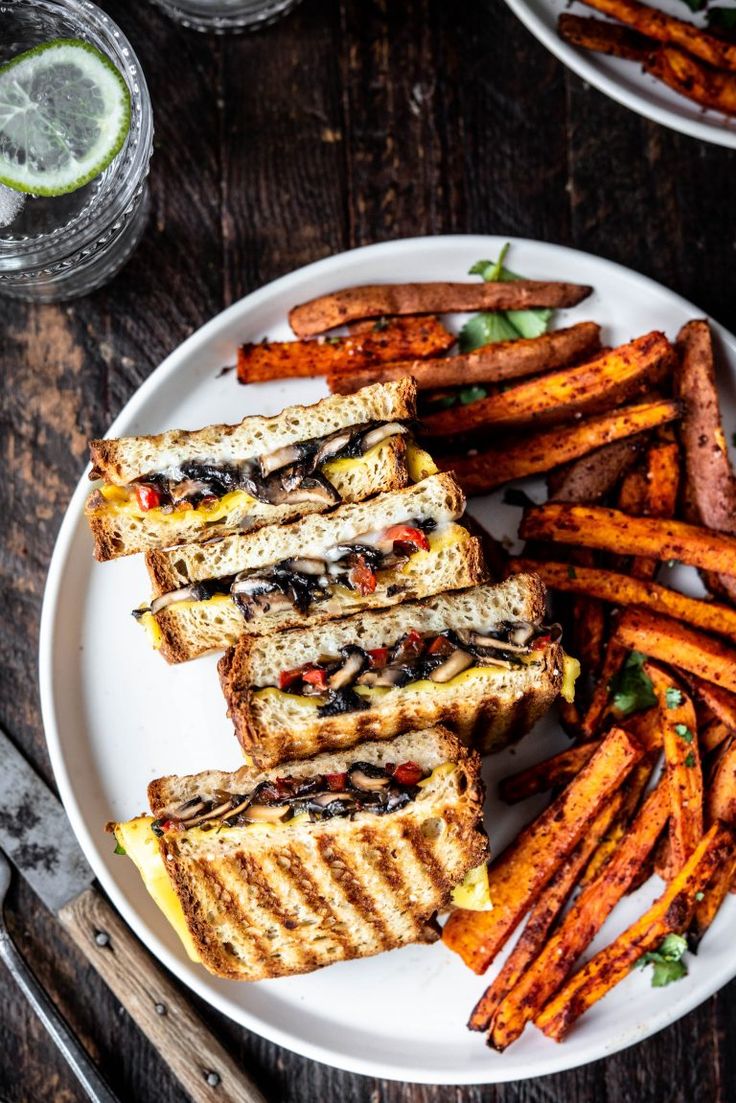 grilled sandwiches and sweet potato fries on a white plate