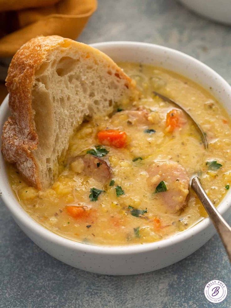 a white bowl filled with soup next to a piece of bread