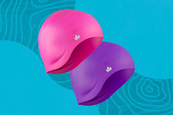 two pink and purple hats sitting next to each other on top of a blue surface