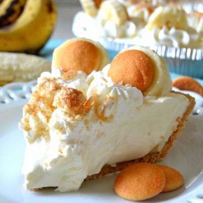 banana pudding pie on a white plate with bananas in the background and text that reads, my best recipes banana pudding pie