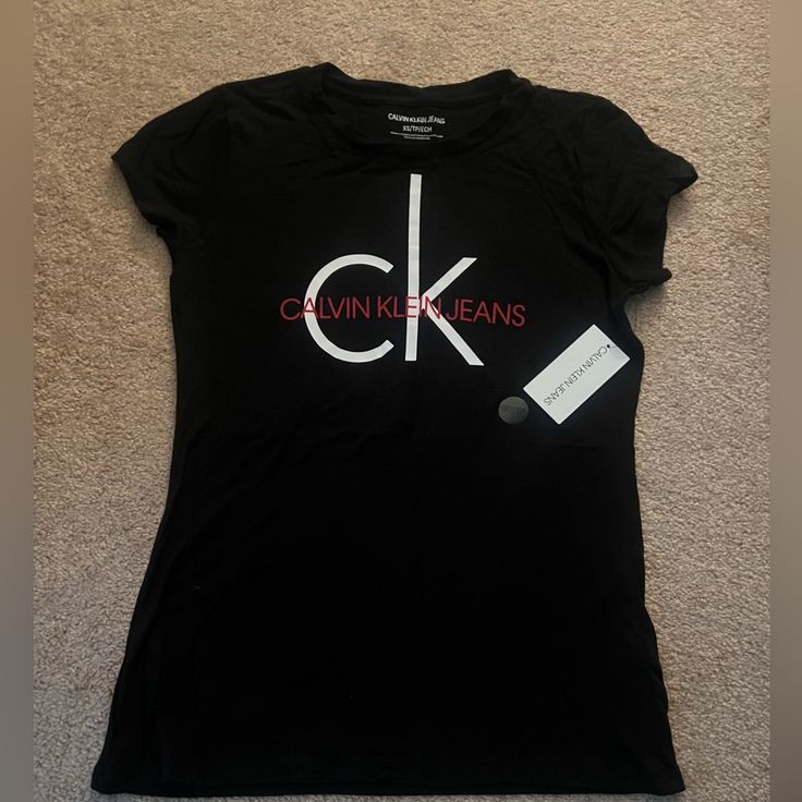 Brand New With Tags Still Intact. Fitted Short Sleeve Calvin Klein T-shirt, Calvin Klein Black T-shirt For Streetwear, Trendy Black Calvin Klein Tops, Calvin Klein Black Tops With Letter Print, Calvin Klein Black Top With Letter Print, Trendy Calvin Klein Top With Graphic Print, Calvin Klein Graphic T-shirt For Streetwear, Calvin Klein Graphic Tee For Streetwear, Calvin Klein Logo Print T-shirt For Streetwear