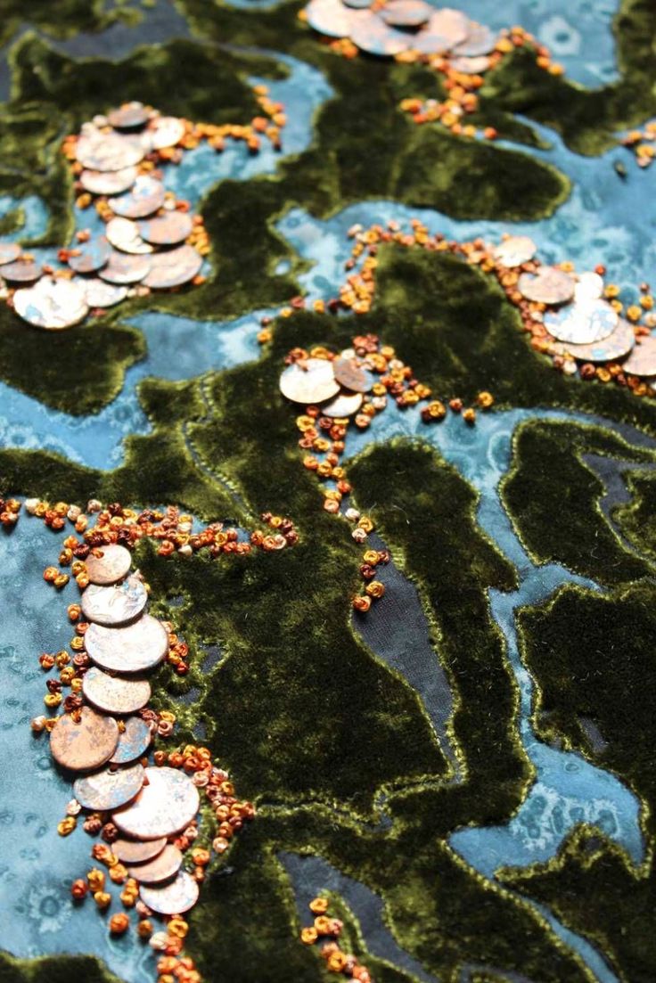 a close up view of some buttons and beads on a surface with blue water in the background