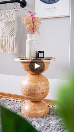 a wooden table topped with a vase filled with flowers on top of a carpeted floor