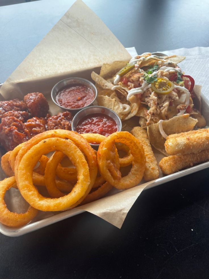 a tray filled with onion rings and other foods