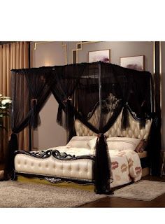 a black canopy bed sitting on top of a wooden floor next to a white rug