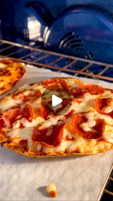 two pepperoni pizzas sitting on top of an oven rack next to each other