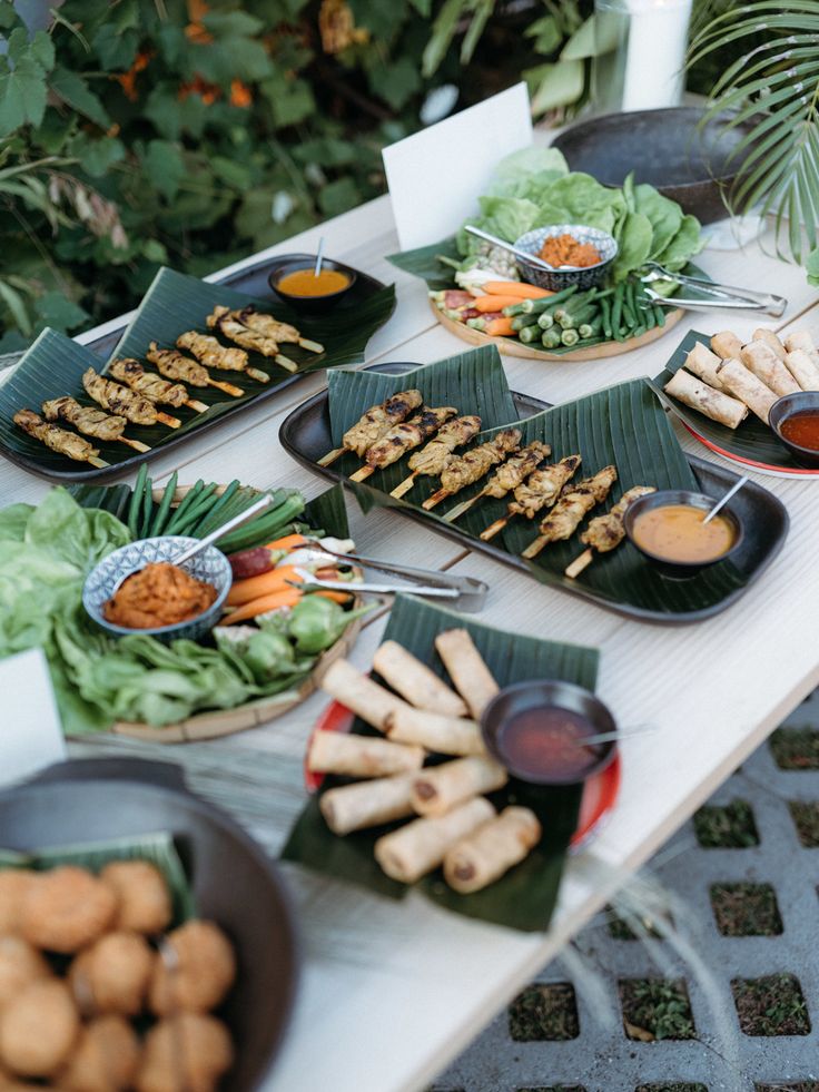 a table topped with lots of food and plates filled with different types of foods on top of it