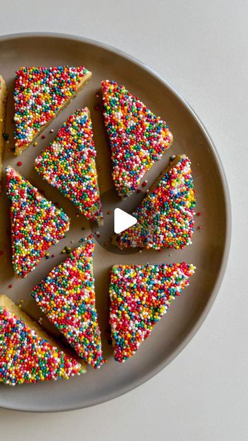 several pieces of cake with colorful sprinkles on a white and gray plate