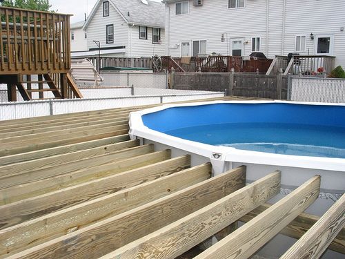 an above ground swimming pool with steps leading up to it and a deck in the background