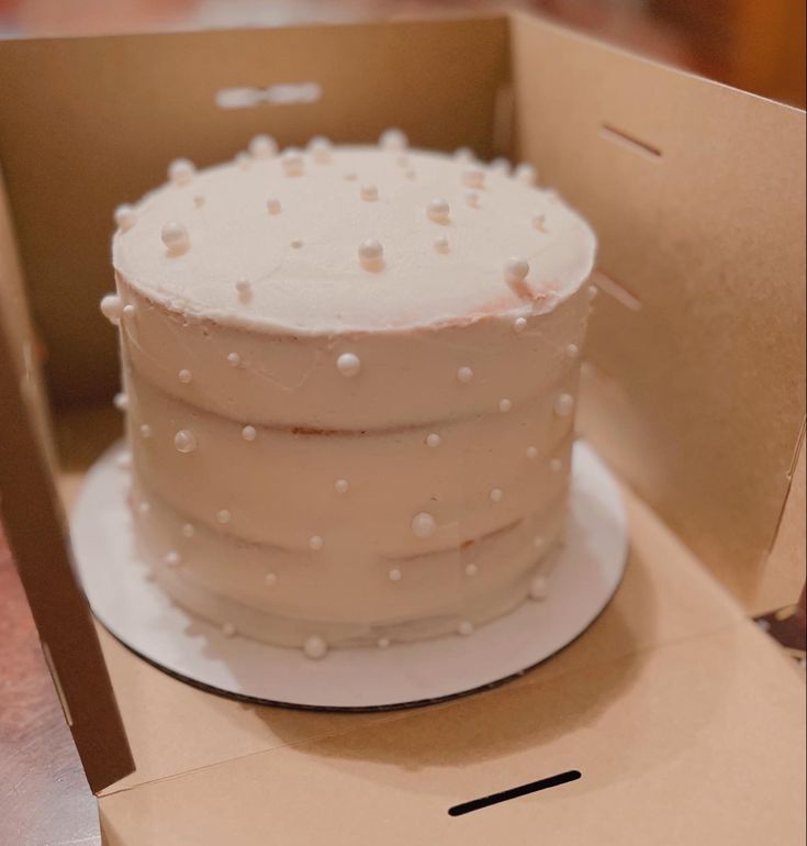 a white cake sitting in a box on top of a table