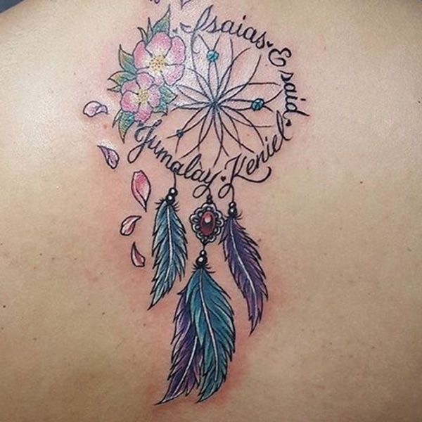 the back of a woman's shoulder with a dream catcher and flowers on it