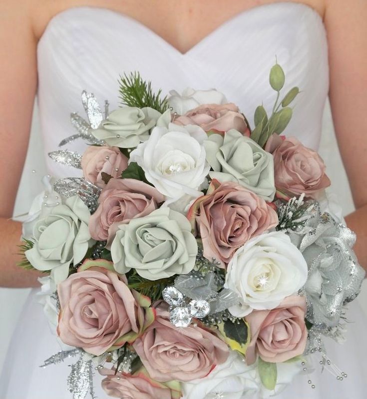 a bride holding a bouquet of pink and white flowers in her hands with silver sequins