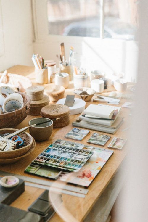 a wooden table topped with lots of craft supplies