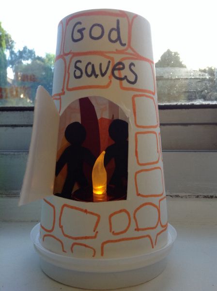 a candle that has been placed in a paper cup with the words god saves written on it