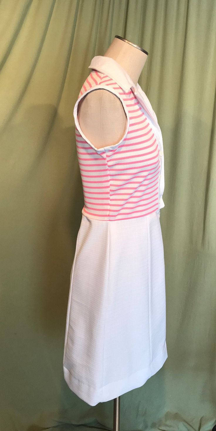 "This is a cute vintage dress from the early 70s. No Brand label only a care & size tag. Tagged a size 14. The bust measures 36\", waist 30\", see measurements below, but it would look best on a slightly smaller bust & waist. Made of a pink & white polyester. The dress is a zip & button front shirt dress. It buttons to the waist & below that is a short nylon zipper. It is sleeveless with a lapel style collar. The top half is pink & white horizontal stripe & the skirt Vintage White A-line Sleeveless Dress, White Retro Mini Dress For Day Out, Retro Stretch Sleeveless Mini Dress, White Retro Sleeveless Spring Dress, White Sleeveless Mod Dress, Retro Sleeveless Mini Dress For Day Out, White Sleeveless Mod Mini Dress, Fitted Mod Sleeveless Summer Dress, Mod Fitted Sleeveless Summer Dress