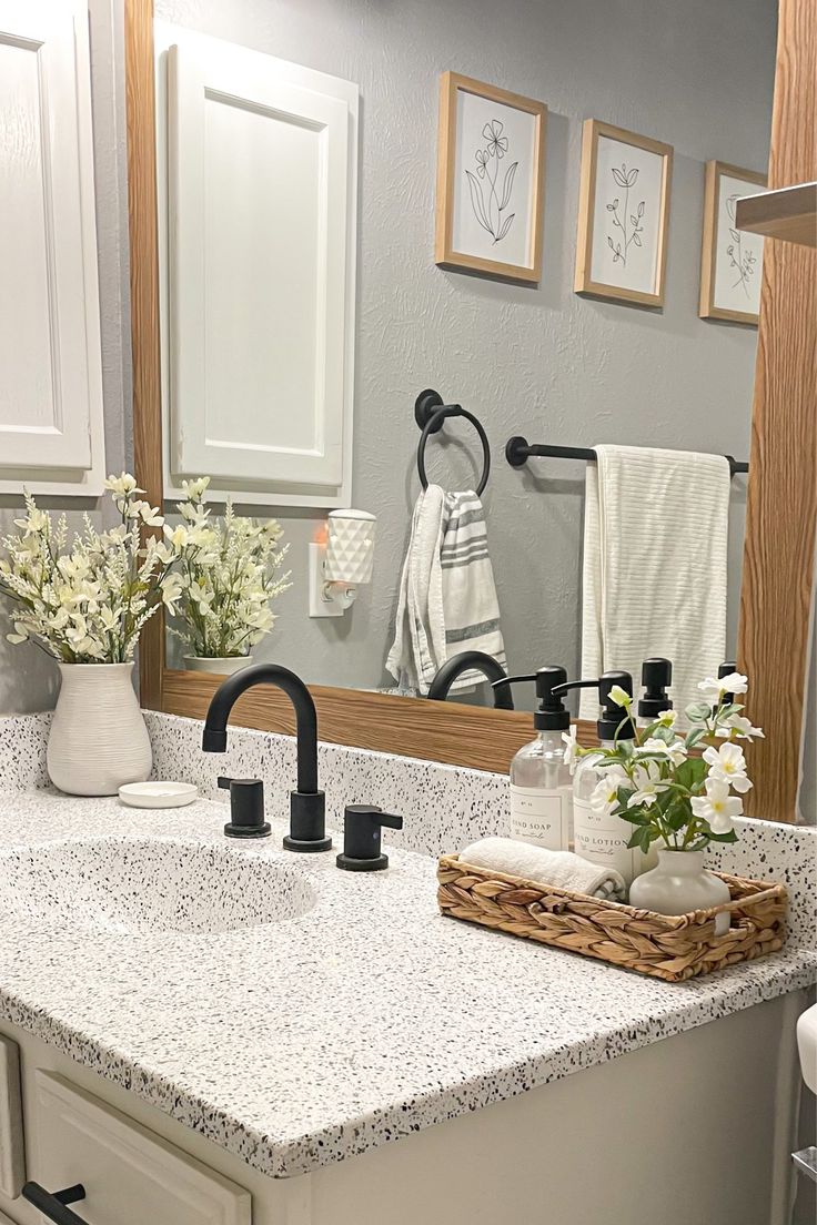 a bathroom with white cabinets and marble counter tops