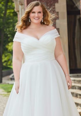 a woman in a white dress posing for the camera with her hands on her hips