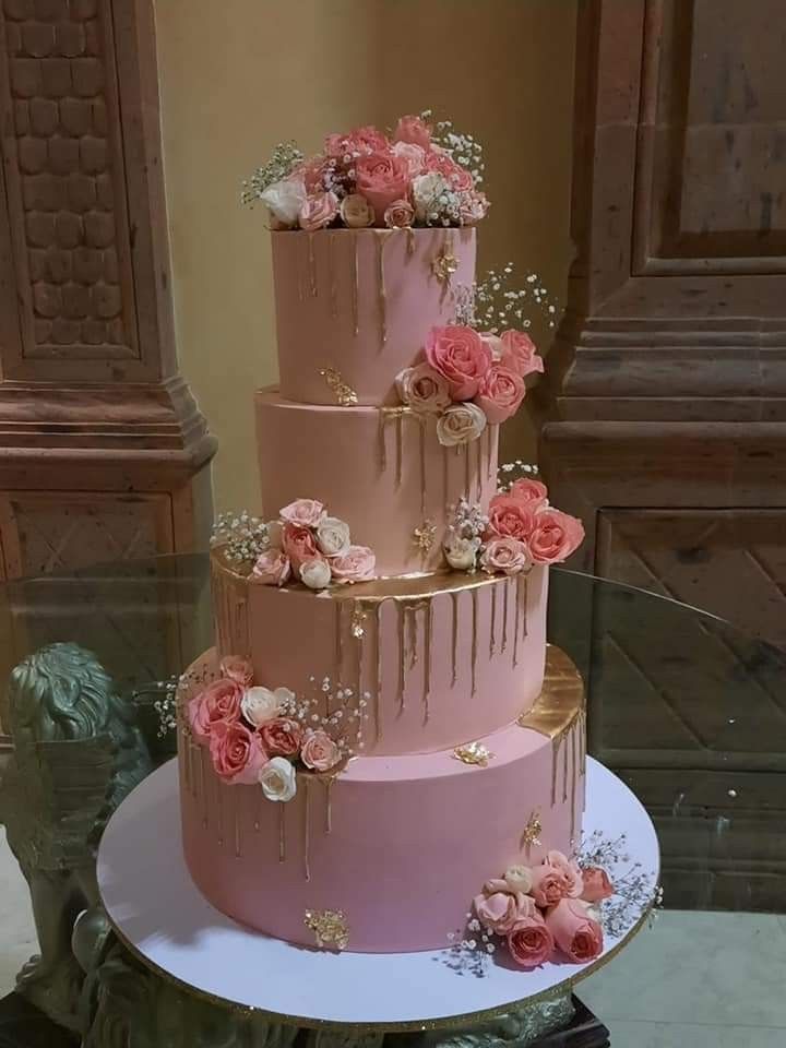 a three tiered cake with pink flowers on top