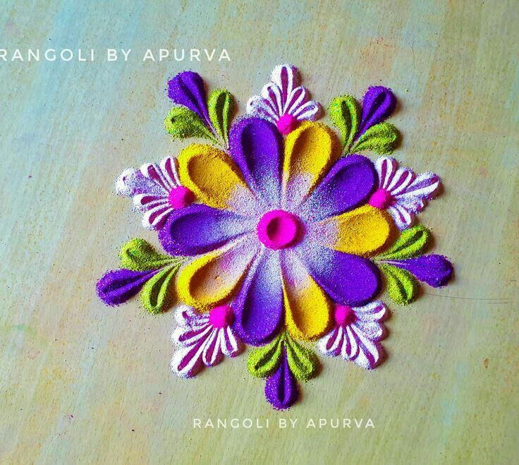 an image of a colorful flower made out of felt on a wooden table with text overlay that reads rangoli by apurva