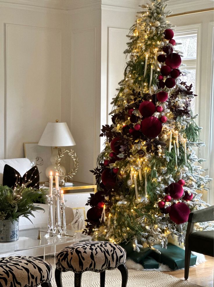 a decorated christmas tree in a living room with zebra print foot stools next to it