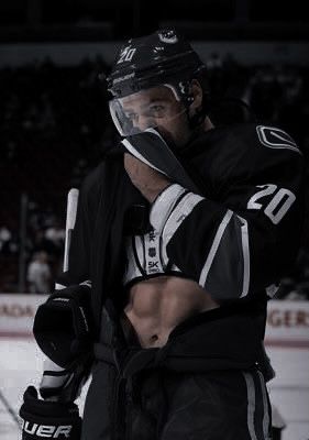 an ice hockey player is wiping his face