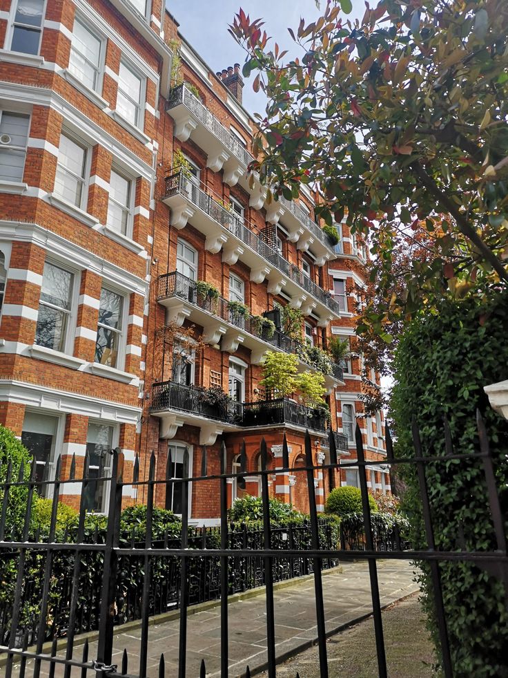 an apartment building with many balconies and plants on the balconies in front