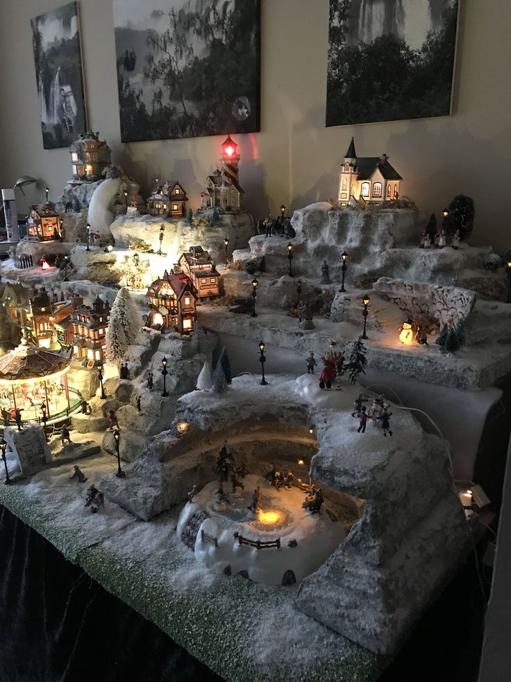 a christmas village with lights and snow on the ground