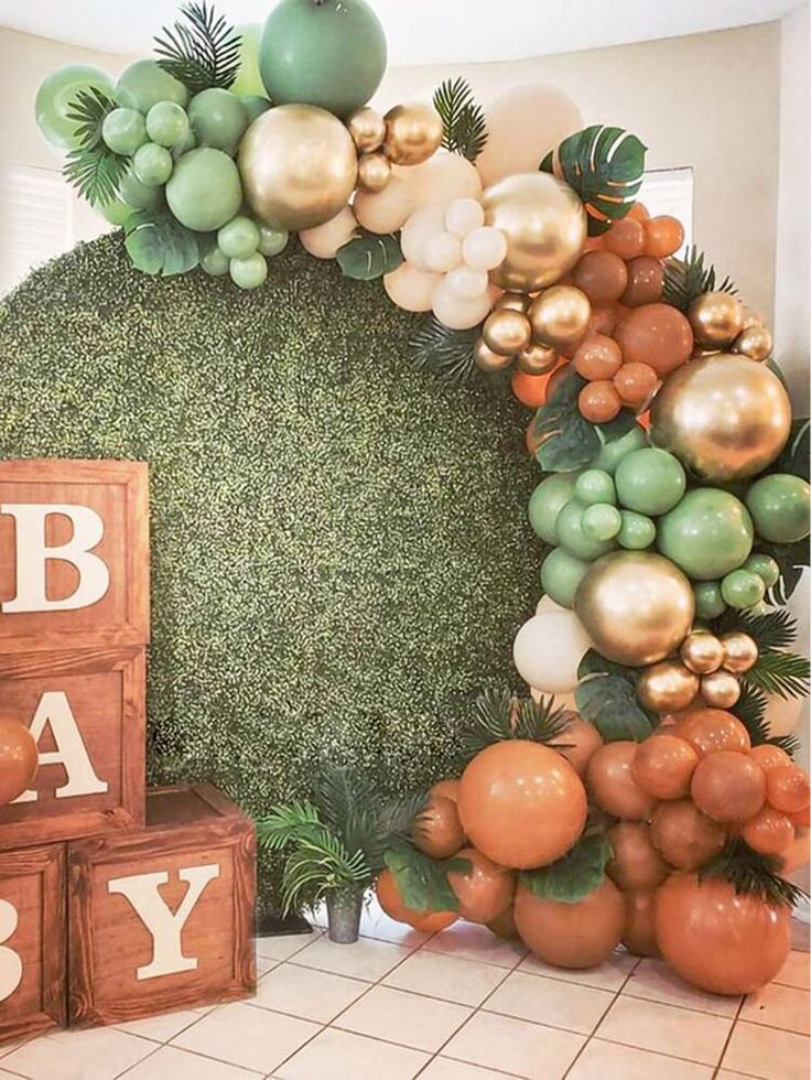 a baby shower is decorated with balloons and greenery