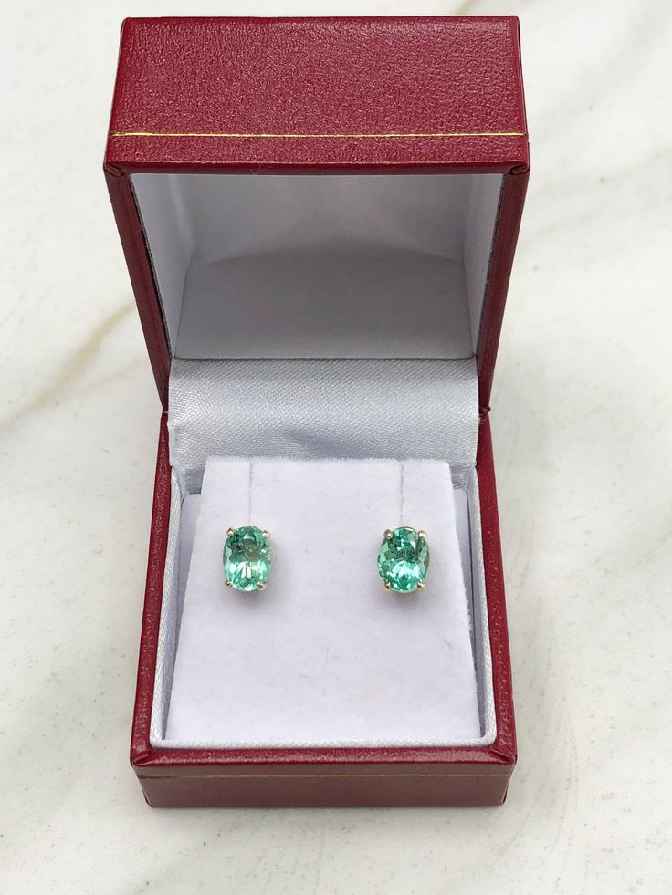 Featured here is a stunning set of oval Colombian emerald studs in fine 14K yellow gold. Displayed are vivacious medium-green emeralds with incredible transparency, accented by a simple four-prong gold mount, allowing for the emerald to be shown in full view. The earth mined, green Colombian emeralds have a desirable lush green color with excellent qualities. These earrings are ideal for everyday use and are the perfect accessory to any outfit. Approx Total Carat Weight: 2.0-carats Setting Style Oval Formal Birthstone Gemstones, Oval Emerald Earrings In Yellow Gold, Yellow Gold Oval Emerald Earrings, Oval Emerald Earrings For Anniversary, Oval Yellow Gold Emerald Earrings, Oval Green Gemstones In 14k Gold, Oval Birthstone Earrings For Formal Occasions, Oval 14k Gold Gemstones For Gift, Oval 14k Gold Gemstones As Gift