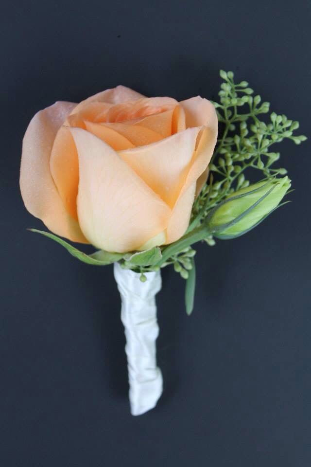 a single orange rose with green stems on a black background