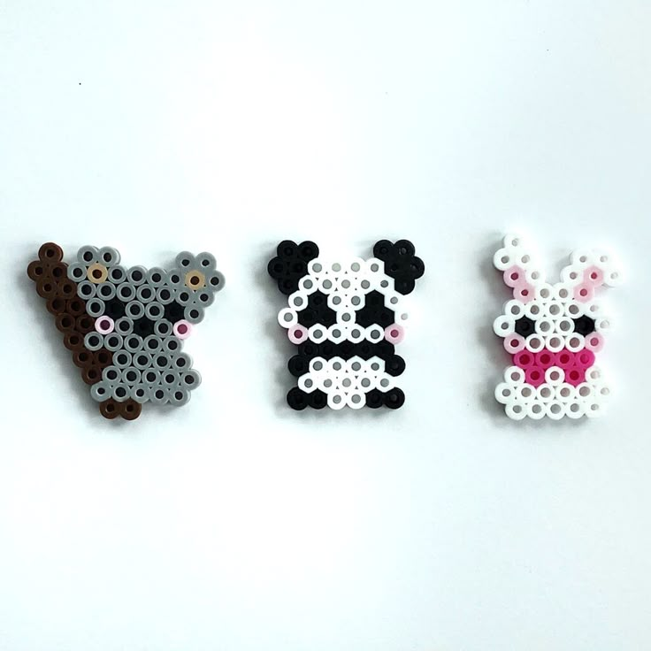 three pieces of perler bead art on a white surface